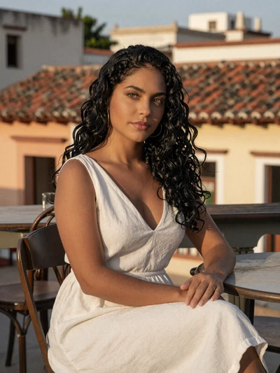 Lisandra, 28, Cuban woman from Camagüey in white linen dress at historic outdoor cafe - Latin 312 verified profile